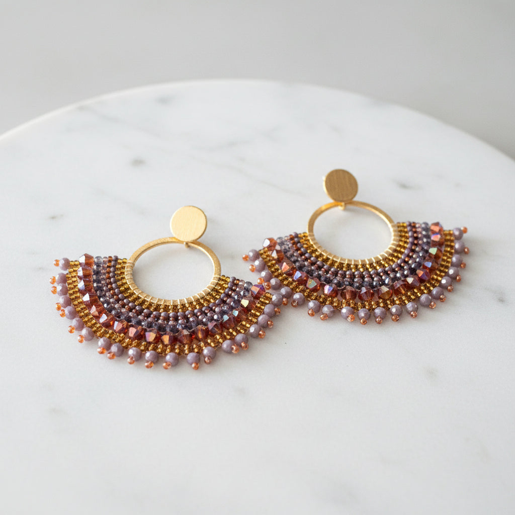 Beaded earrings on a branded card with a beige background
