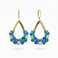 Gold and blue beaded earrings on a Usizo branded card against a beige background