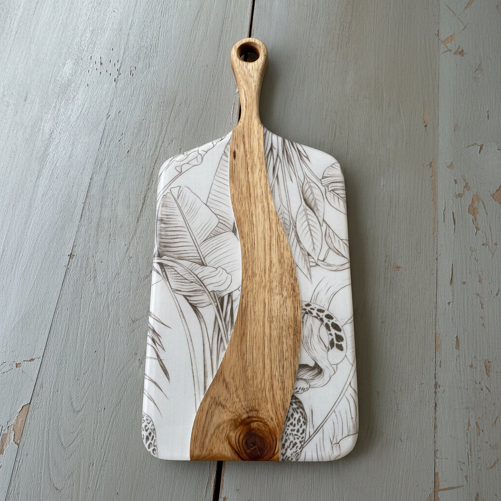 Wooden cheese board with brown outline design of Delicious Monsters on white background.
