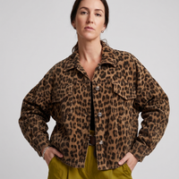 Person wearing a leopard print jacket and green pants on a plain background