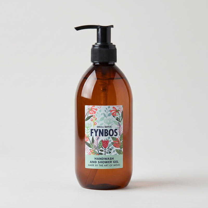 An amber glass pump bottle of Fynbos Handwash and Shower Gel with a black dispenser and a colorful botanical label, set against a plain light gray background.