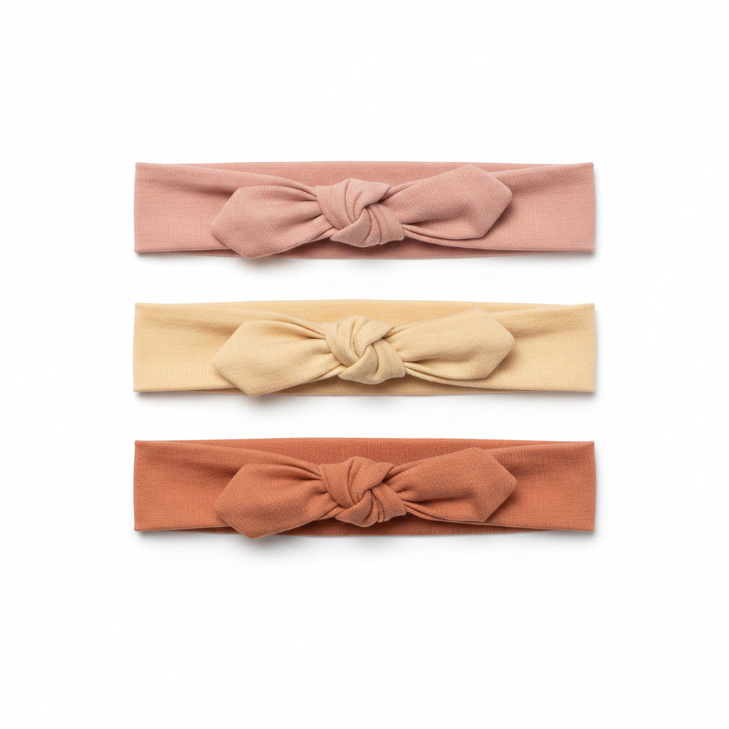 Three headbands in pink, beige, and brown on a white background