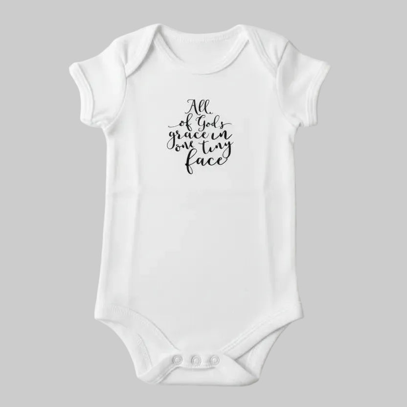 White baby onesie with text on a light background