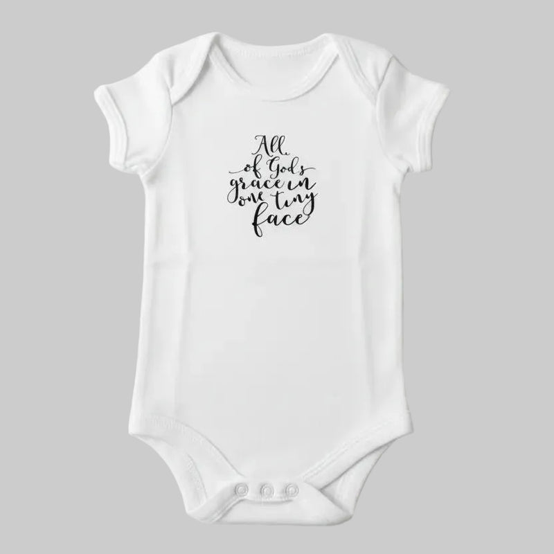 White baby onesie with text on a light background