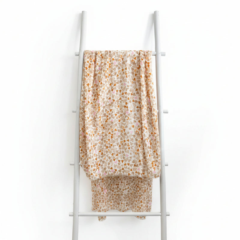 Heart-patterned fabric draped over a white ladder against a teal wall