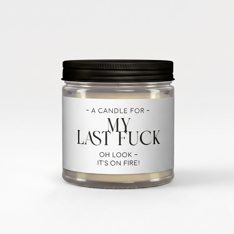 A novelty jar candle with a black metal lid and a white label that reads 'MY LAST FCK OH LOOK IT'S ON FIRE!' on a clean white background.