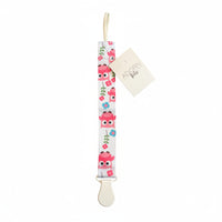 Owl-patterned baby pacifier clip on a textured surface with a visible brand tag.