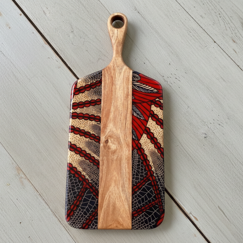 Wooden cutting board with red, black and cream design.