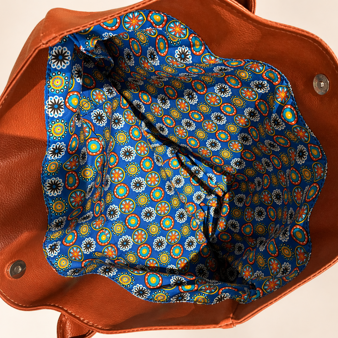 Brown leather bag with a blue floral interior lining