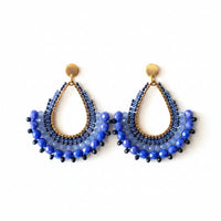 Blue beaded earrings on a Usizo branded card against a beige background